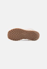 Suela de zapato con un material de goma texturizado, que presenta un dibujo en el relieve para agarre y un color marrón con un borde ligeramente curvado.