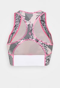 Top sportivo con motivi floreali neri e righe, rifiniture rosa e un elastico bianco. Presenta un design con schiena a racer e pannelli in rete per la traspirabilità.