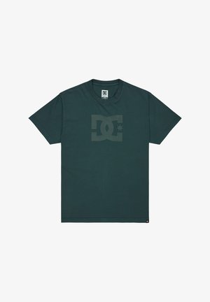 Tmavo zelené bavlnené tričko s okrúhlym výstrihom a krátkymi rukávmi. Na prednej strane sa nachádza veľké tonálne logo DC. Hladká textúra, voľný strih.