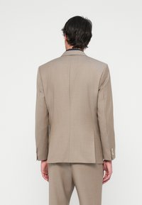 Ανοιχτό μπεζ σακάκι με λείο υφή και δομημένο σχέδιο. Διαθέτει έναν αερισμό, επιμήκεις πέτα και κουμπωτές μανσέτες.