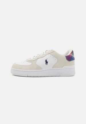 White and beige sneakers with suede and leather materials. Features a plaid accent at the heel and a logo on the side. Rubber sole.