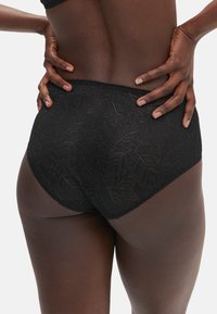 Slip hipster in pizzo nero, con motivo a foglia, bordi senza cuciture e una texture morbida per comfort ed elasticità.