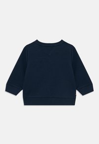 Námořnická modrá mikina s dlouhými rukávy, žebrovanými manžetami a kulatým výstřihem. Hladká textura s malou logovou aplikací na lemu.