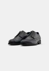 Pair of black leather formal lace-up dress shoes with stitching details on a plain white background.