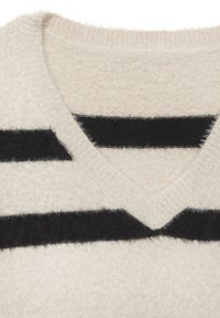 Sveter s výstrihom do V v jemnom béžovom materiáli so čiernymi horizontálnymi pruhmi. Textúrovaný povrch so slabým chlpatením a rebrovanými okrajmi.