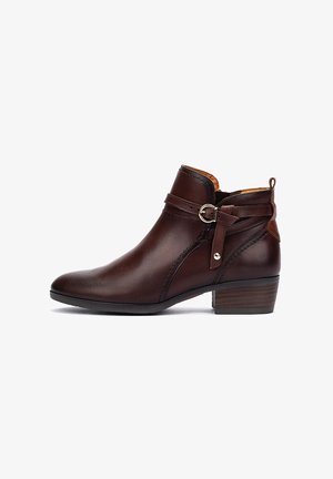 Bottines en cuir marron avec un bout arrondi, dotées d'une sangle latérale et d'un détail en boucle, d'un petit talon empilé et de coutures décoratives.
