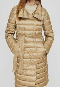 Gepolsterter beiger Mantel mit einem taillierten Gürtel, breiten Revers, horizontaler Steppung und langen Ärmeln. Das Material hat eine glänzende, glatte Textur.