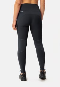 Leggings sportivi neri con vita alta, caratterizzati da pannelli grigio scuro a contrasto e una texture liscia. Logo visibile sul retro.