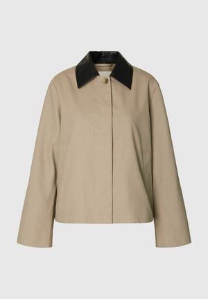 Veste beige à manches longues avec une fermeture à un seul bouton, dotée d'un col pointu en cuir noir contrastant.