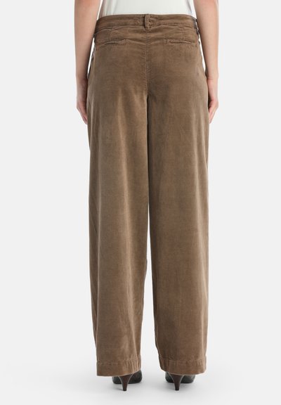 Bruine corduroy wijde broek met een gestructureerd ribbelpatroon, voorzien van achterzakken en een aansluitende tailleband. De zoom eindigt boven de schoenen.