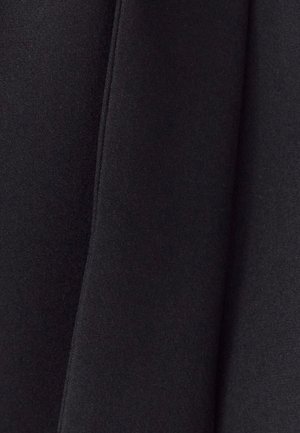 Crna tkanina s glatkom, mat teksturom i finim tkanjem. Uzduž rubova su vidljive šavove, što stvara strukturirani izgled.