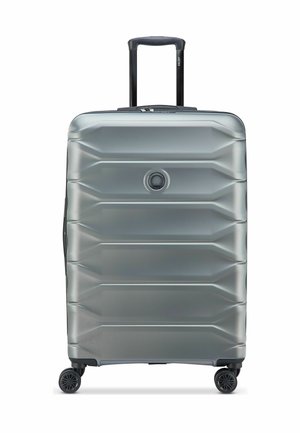 Valise rigide argentée avec quatre roues et une poignée rétractable noire étendue, vue de face sur fond blanc.