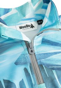 Fleece zip-up-tröja i nyanser av blått med ett abstrakt mönster. Har en grå dragkedja, stjärnformad dragregel och etikett med "WeeDo funwear".