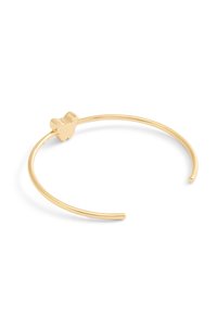Pulsera de metal de color dorado con una banda redonda y lisa, y un acento simple en forma de corazón, con un acabado pulido.