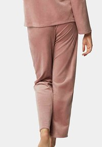 Pyjama set in zacht roze stof met een ontspannen pasvorm. Het bovenstuk heeft lange mouwen en een ronde zoom, terwijl de broek iets taps toeloopt.