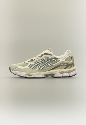 Hellbeiger und olivfarbener Asics Laufschuh mit weißer Sohle, seitlichen Logostreifen und gepolsterter Zwischensohle, von der Außenseite auf schlichtem Hintergrund betrachtet.