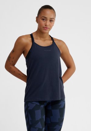 Marine blauwe tanktop met sportief ontwerp, voorzien van dunne bandjes en textuurstof. Gecombineerd met marine blauwe leggings met een patroon van rechthoekige vormen.