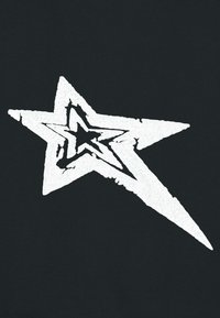 Tissu noir avec un grand graphique d'étoile blanche. L'étoile a une texture rugueuse avec un design vieillissant, présentant une forme d'étoile centrale à l'intérieur.