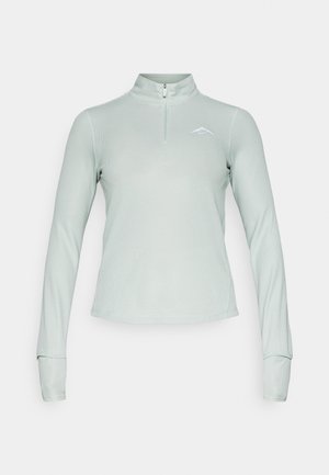 Haut à manches longues vert clair avec un col zippé quart de tour. Présente une texture lisse et un petit logo sur la poitrine.