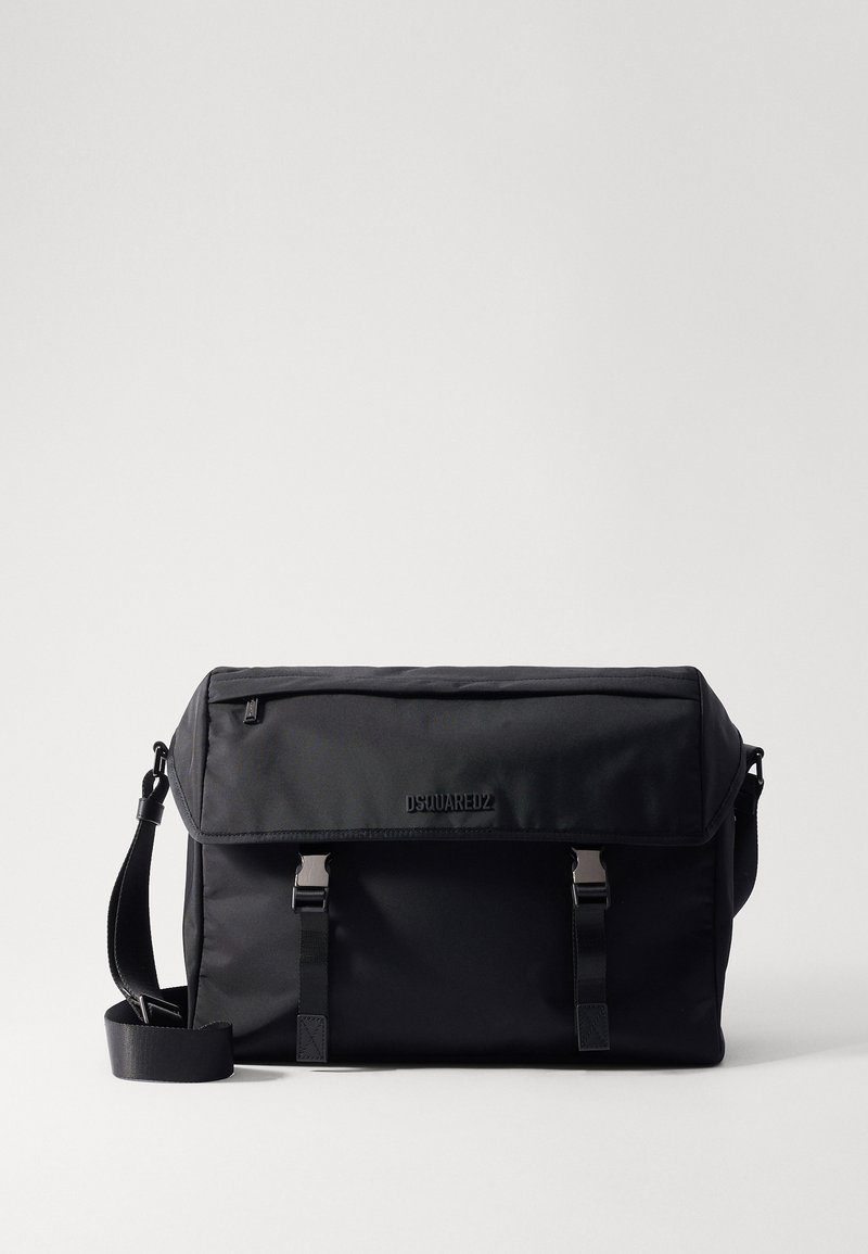 Schwarze Umhängetasche aus glattem Nylonmaterial, mit Klappenverschluss, zwei vorderen Riemen und einem verstellbaren Schultergurt. Logo auf der Vorderseite.