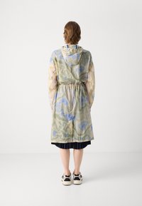 Hooded, lightweight jacket with a multicolored abstract pattern in greens, blues, and beige; cinched waist, long sleeves, knee-length.