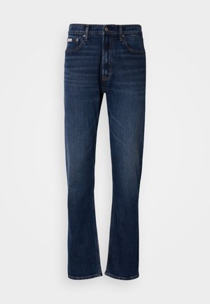 Tumedast sinine teksapüksid otse jala disainiga, millel on viis taskut, lukuga tõmblukk ja kontrastõmblused. Tekstuuriga kangas sileda viimistlusega.