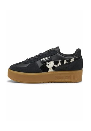 Sort Puma Palermo sneaker med tan-farvet tyk sål, sort ruskind og læderoverdel samt hvid-sorte dyreprintstriber på siden.