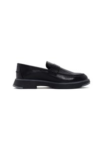 Mocasines de cuero negro con un acabado suave, diseñados con una suela negra texturizada baja y un sutil acento a lo largo del borde superior.