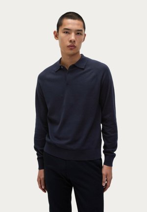 Polo de manga larga azul marino oscuro hecho de tejido suave. Presenta un cuello clásico, tapeta de botones y puños y dobladillo acanalados para un ajuste ceñido.
