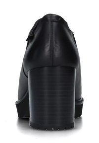 Scarpa nera in pelle con tacco alto, caratterizzata da un tacco spesso e scanalato e una superficie liscia con punta arrotondata. Design minimalista, privo di decorazioni.