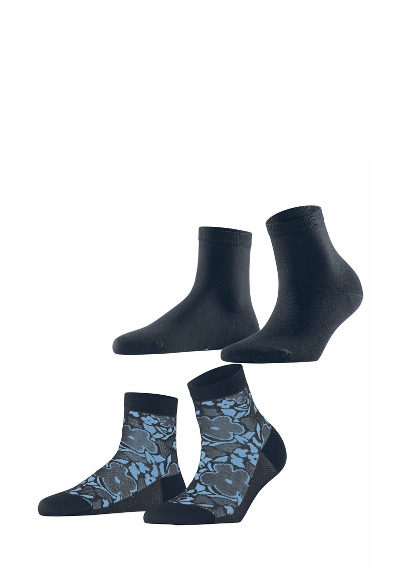 Vier paar sokken: twee effen zwarte enkelsokken en twee gemusterde sokken met een blauw bloemenpatroon op een donkere achtergrond.