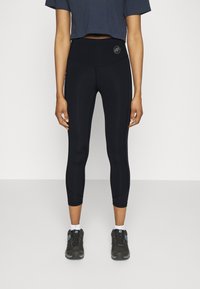Zwarte sportleggings met een hoge tailleband, voorzien van een zachte textuur, een aansluitend ontwerp en subtiele paneeldetails langs de zijkanten.