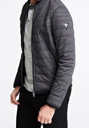 Gequiltte grijze bomberjack met een rechtopstaande kraag, een rits aan de voorkant en zwarte afwerking. Heeft een slank ontwerp en zijzakaccent.