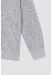 Tissu de sweat-shirt gris avec une texture mouchetée, doté d'une poche avant et de poignets côtelés. Le design est décontracté avec une coupe ample.