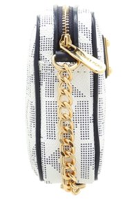 Valkoinen teksturoitu olkapussukka mustalla pilkullisella kuviolla, kullanvärinen vetoketjun vetäjä, jossa on kaiverrus "Michael Kors", ja kultaketjusarja kiinnitettynä.