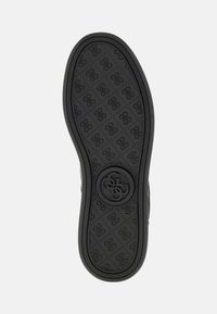 Talpa de pantof din cauciuc negru cu un model texturat de logo-uri și linii diagonale, având un emblema circulară în centru.
