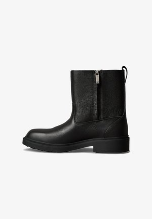 Stivaletto alla caviglia in pelle nera con finitura testurizzata, chiusura laterale con zip, suola robusta e linguetta sul retro per facilitare la calzata.