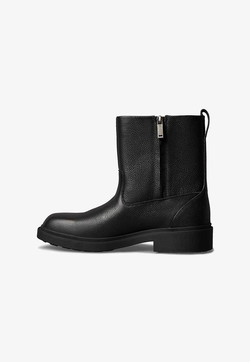 Czarny skórzany botek za kostkę o teksturowanej powierzchni, z bocznym zamkiem, solidną podeszwą i pętelką z tyłu ułatwiającą zakładanie.