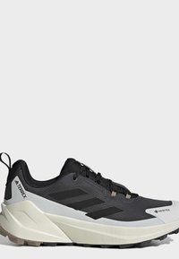 Μαύρο και γκρι παπούτσι trail running Adidas Terrex Gore-Tex με υφή στη σόλα και θηλιά στην φτέρνα.