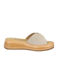 Sandalias deslizantes de ante beige con un acento plateado redondo, plantilla acolchada y una suela de goma rugosa en color marrón. Diseño plano para un uso fácil.