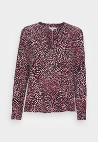 Blouse pour femme à manches longues avec un motif abstrait à taches roses, blanches et noires et un décolleté en V.