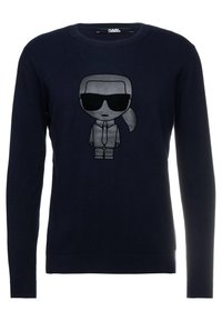 Mörkblå tröja i mjukt material med en tecknad karaktär i solglasögon tryckt på framsidan. Långärmad, rundhalsad design.