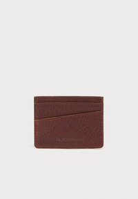 Καφέ δερμάτινη θήκη καρτών με υφή στην επιφάνεια, διαθέτει τέσσερις θήκες για κάρτες και διαγώνιο διακοσμητικό στοιχείο. Το λογότυπο είναι ανάγλυφο στην κάτω δεξιά γωνία.