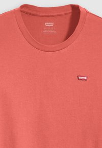 Rød bomulds T-shirt med rund hals, der har et lille broderet Levi's logo på venstre bryst og en blød, glat overflade.