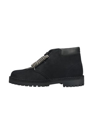 Schwarzer Wildleder-Knöchelboot mit dicker Gummisohle, gepolstertem Schaft und schwarz-weißen gestreiften Schnürsenkeln, locker gebunden.
