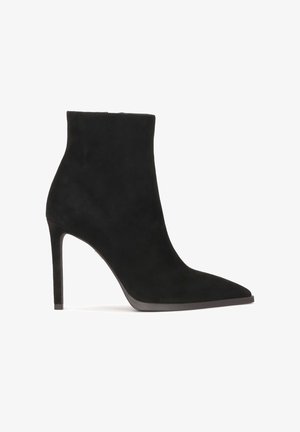 Fekete velúr bokacsizma hegyes orral és karcsú tűs sarokkal, sima textúrával és minimalista dizájnal.