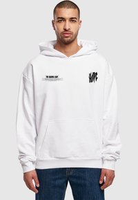 Hvid hoodie med frontlomme, med sort grafisk tekst "THE GUIDING LIGHT" og "HOPE" på ærmerne. Blødt, bomuldsblandet stof.