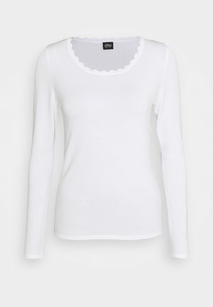Witte longsleeve met geschulpte ronde halslijn, aansluitende stijl en zachte stof, getoond tegen een effen lichte achtergrond.