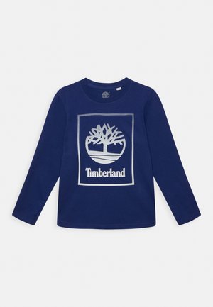 Chemise bleu marine à manches longues avec un logo arbre Timberland argenté et le nom de la marque centré sur le devant.