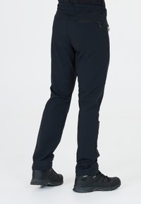 Svarta, stretchiga vandringsbyxor med en slimmad profil. Har en blixtlåsficka på ryggen och passar bra ihop med svarta vandringskängor.